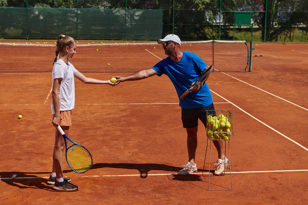 A professional tennis player and her coach training on a sunny day at the tennis court. Training and preparation of a professional tennis player. - Foto, imagen