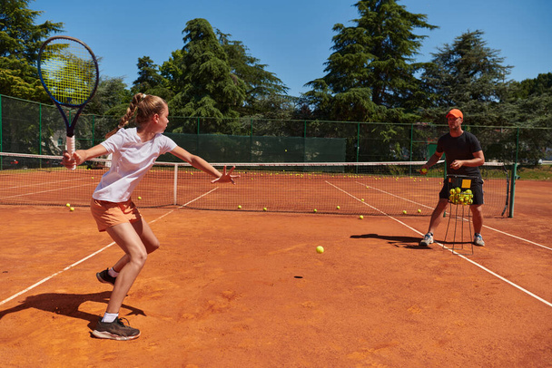 A professional tennis player and her coach training on a sunny day at the tennis court. Training and preparation of a professional tennis player. - Fotografie, Obrázek