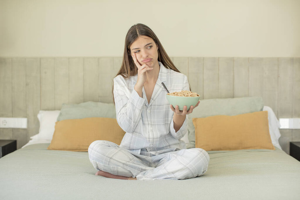 young pretty woman feeling bored, frustrated and sleepy after a tiresome. breakfast concept - Photo, Image