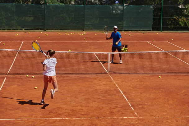 A professional tennis player and her coach training on a sunny day at the tennis court. Training and preparation of a professional tennis player. - Foto, afbeelding