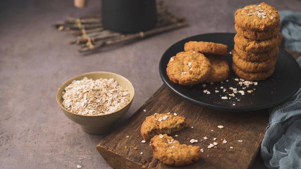 Homemade oatmeal raisin cookies with cup of cappuccino on rustic background. - Фото, зображення