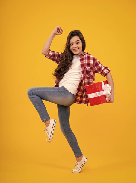Child with gift present box on isolated background. Presents for birthday, Valentines day, New Year or Christmas. Happy teenager, positive and smiling emotions of teen girl - Foto, afbeelding