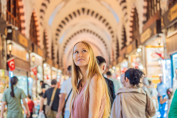 A tourist woman walks among the countless shops at the Grand Bazaar and Egyptian Bazaar in Istanbul. Shopping and travel in Turkey concept. Istanbul historical Egyptian Bazaar. Misir Carsisi, spice - Foto, Bild