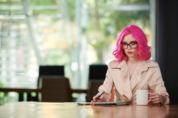 Ritratto di giovane donna d'affari seria con vibrante documento di lettura dei capelli rosa su tablet - Foto, immagini
