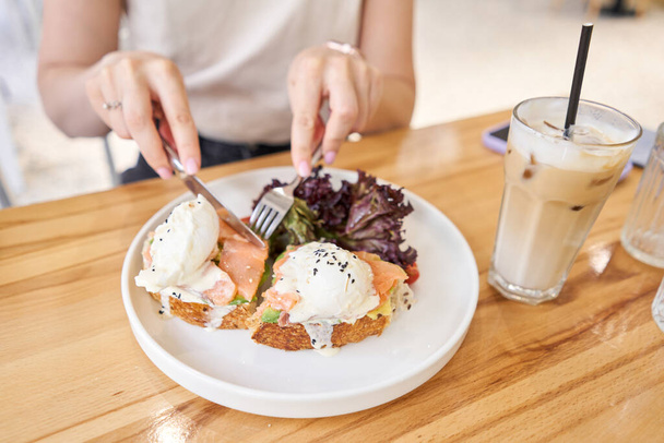 piatto ristorante Brioche con uovo in camicia con salmone e avocado. Pane delizioso con verdure. Foto di alta qualità - Foto, immagini