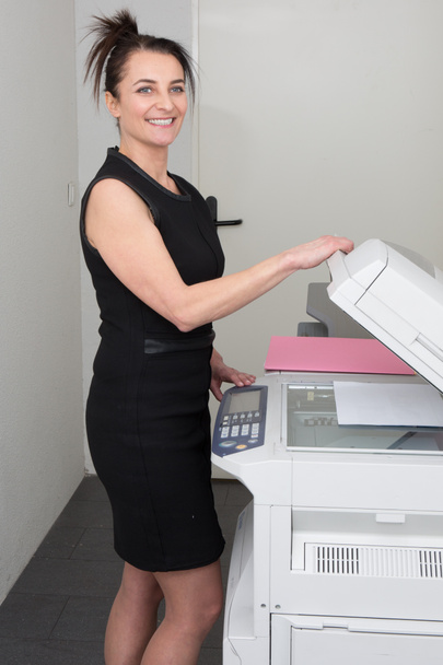 Woman at work, with a copy machine - Photo, Image