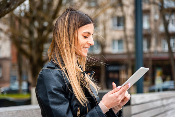 Mladý hipster dívka drží PC tablet ve městě.Cestovatel žena pomocí tablet.reading průvodce mapa na tablet počítač PC, pomocí mobilního internetu.Žena píše textovou zprávu nebo obsah. - Fotografie, Obrázek