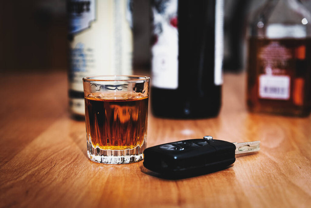 a glass of whiskey and car keys on the table.Drunk driving.Drink and auto keys.To drive or not to drive, alcohol addiction concept. - Fotoğraf, Görsel