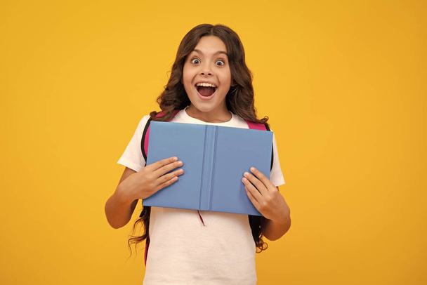 Back to school. Teenager school girl hold book and copybook ready to learn. School children with school bag on isolated yellow studio background. Shocked surprised teenager girl - Foto, immagini