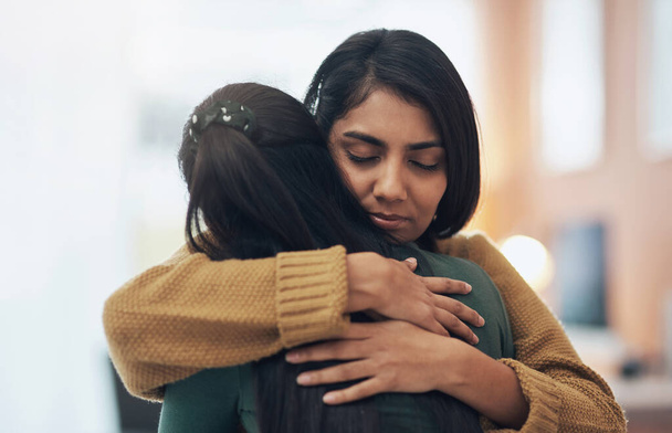 Friends, hug and support of women together in a house with love, care and empathy. Indian sisters or female family in a room while sad, depressed and hugging for comfort, trust and quality time. - Foto, afbeelding