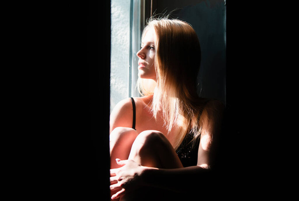 Sensual woman with shadows on beautiful face. Sensual girl near window - Photo, Image