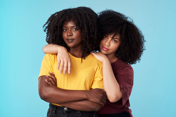 Portrait, diversity and support with friends on a blue background in studio together for freedom or empowerment. Love, trust and an attractive young black female standing arms crossed with a friend. - Photo, Image