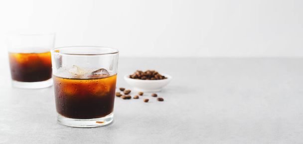 Холодный кофе, холодный кофе со льдом на ярком светло-сером фоне, освежающий напиток - Фото, изображение