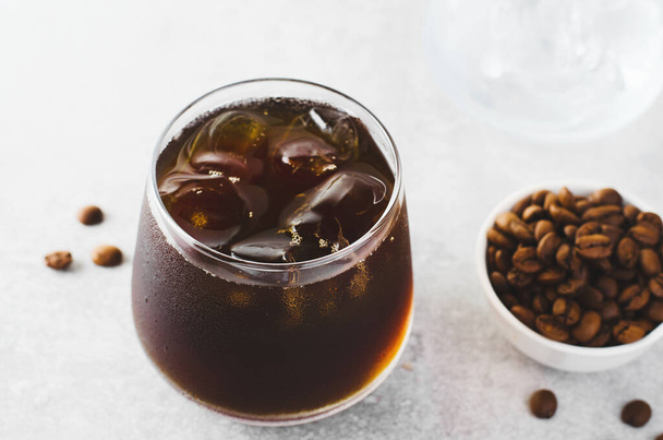 Mrożona kawa, zimny browar kawa z lodem na jasnoszarym tle, orzeźwiający napój - Zdjęcie, obraz