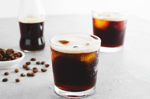 Jeges kávé, pezsgő vagy hideg sör kávé jéggel, világos szürke háttér, frissítő ital - Fotó, kép