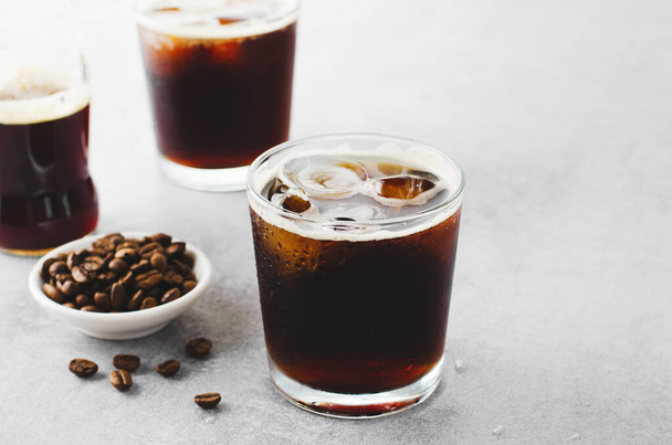 Кофе со льдом, газировка или холодный кофе со льдом на ярком светло-сером фоне, освежающий напиток - Фото, изображение