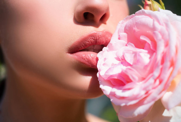 Beautiful woman lips with rose. Natural lip makeup. Closeup beautiful female mouth. Plump full lips - Valokuva, kuva