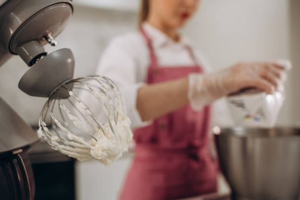 Ένα όμορφο λευκό μίξερ με ένα μεταλλικό κύπελλο στέκεται η μοντέρνα κουζίνα - Φωτογραφία, εικόνα