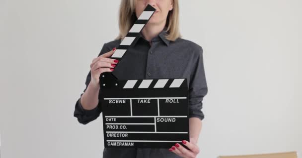 Mujer asistente de dirección golpeando aplaudir mientras filmación primer plano 4k película cámara lenta. Producción cinematográfica y concepto de cine - Imágenes, Vídeo