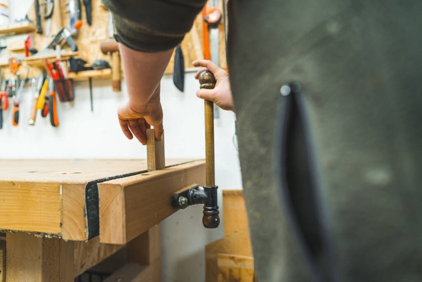 timmerman met behulp van een handmachine in houtbewerking in zijn winkel, houten producten. Hoge kwaliteit foto - Foto, afbeelding