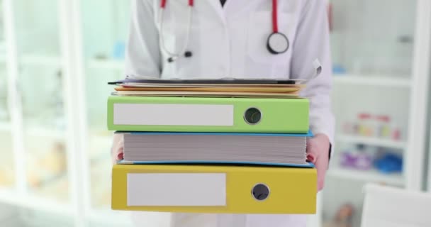 Médico segurando lote de pastas com papéis e documentos em clínica closeup filme 4k. Burocracia no conceito de medicina - Filmagem, Vídeo