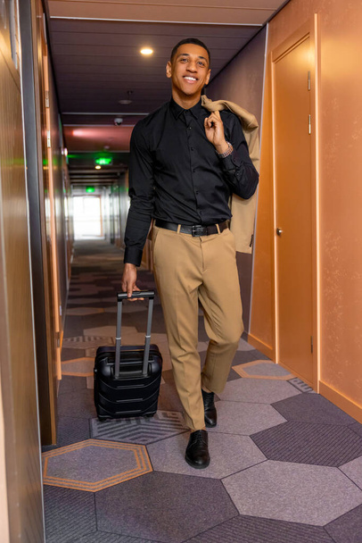 In the hotel. Young good-looking handsome businessman looking for his room in the hotel - Fotografie, Obrázek