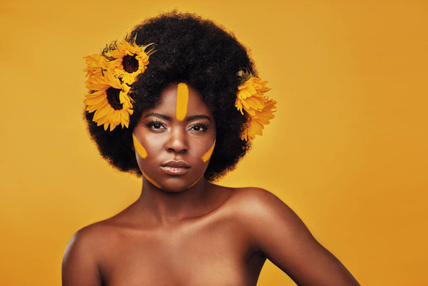 Μακιγιάζ, ηλιοτρόπιο και βαφή με πορτραίτο μαύρης γυναίκας στο στούντιο για ομορφιά, δημιουργικότητα ή άνοιξη. Φυσικά, καλλυντικά και floral με πρόσωπο του μοντέλου σε κίτρινο φόντο για την τέχνη, τον εαυτό αγάπη ή λάμψη. - Φωτογραφία, εικόνα