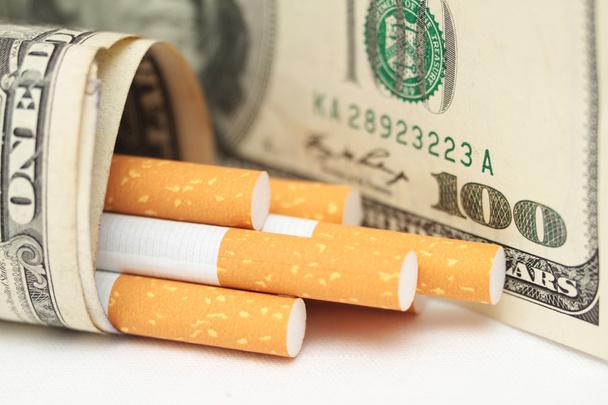 cigarrillos y dinero. hábito caro. fondo blanco - foto horizontal
. - Foto, Imagen