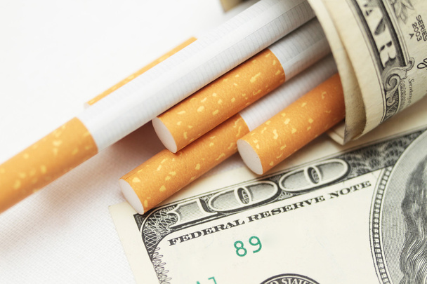 cigarettes et argent. habitude coûteuse. fond blanc - photo horizontale
. - Photo, image