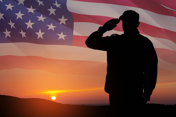 Silhouette of soldier saluting on a background of sunset or sunrise and USA flag. Close-up. Greeting card for Veterans Day, Memorial Day, Independence Day. America celebration. - Photo, image