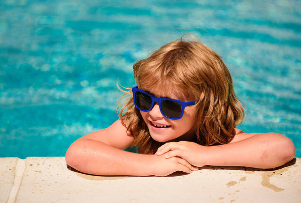 Child in summer pool. Summer kids weekend. Happy boy in sunglasses. Kid in swimming pool. Summertime vacation - Фото, изображение