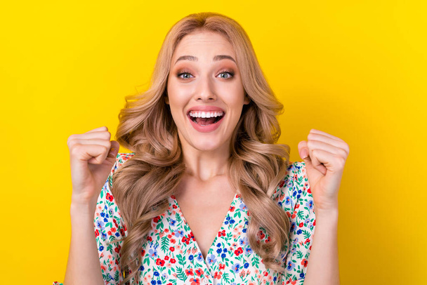 Portrait of funny woman blonde curls fists up hooray wear stylish flower ornament victoria secret sale isolated on yellow color background. - Foto, Imagen