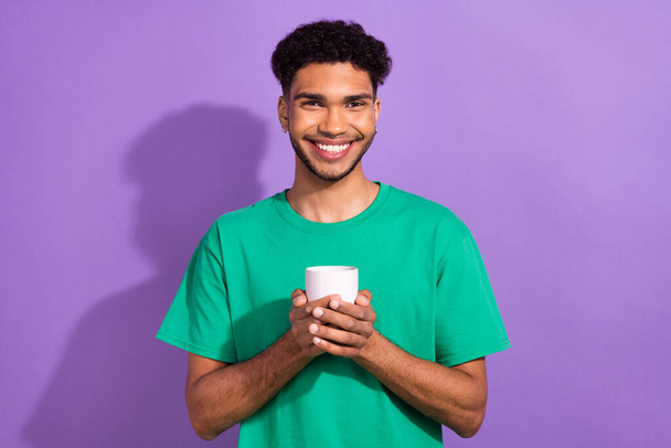 Portrait of peaceful positive person beaming smile hands hold coffee cup isolated on purple color background. - Fotó, kép