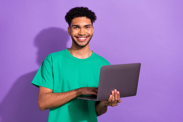 Photo of cool cheerful guy dressed green t-shirt chatting instagram twitter telegram facebook empty space isolated violet color background. - Valokuva, kuva