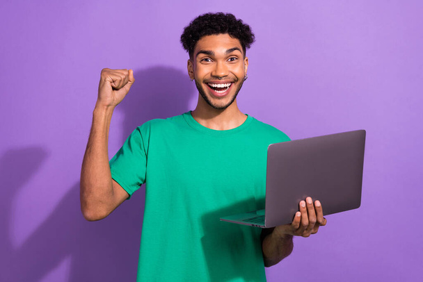 Photo of excited person raise fist celebrate success use netbook isolated on violet color background. - Foto, imagen