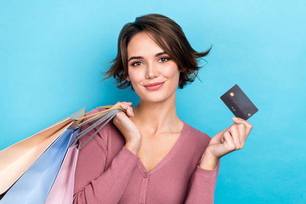 Photo of young bob brown hair girl wear pink shirt hold plastic debit card already purchased bags clothes isolated on blue color background. - Fotoğraf, Görsel
