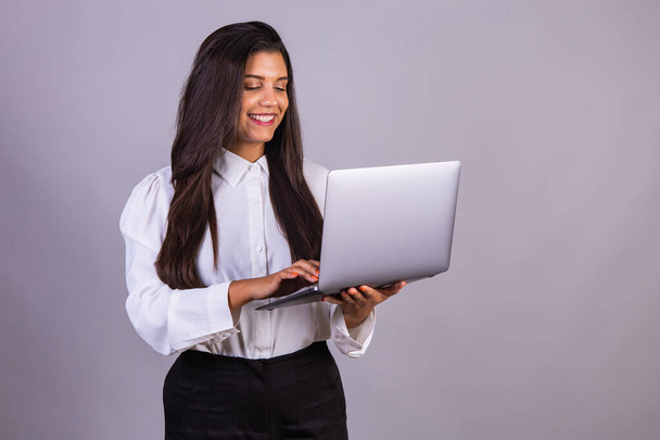 Brazilian woman holding notebook, laptop computer. - Zdjęcie, obraz