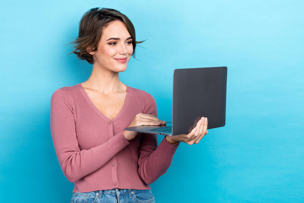 Photo of adorable positive intelligent woman with bob hairstyle dressed pink sweater look at laptop isolated on teal color background. - Foto, Imagem
