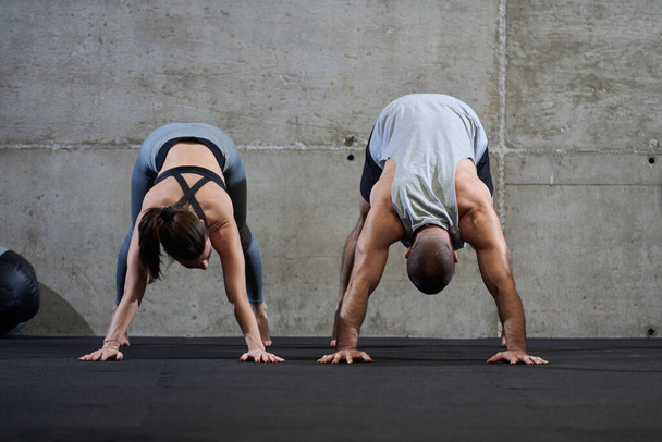 Una coppia attraente in palestra impegnati in vari esercizi di stretching insieme, mostrando la loro dedizione al fitness, flessibilità e benessere generale. Con movimenti sincronizzati, essi - Foto, immagini