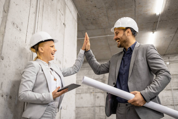 Architect giving high - five to construction engineer for successful cooperation. - Photo, Image