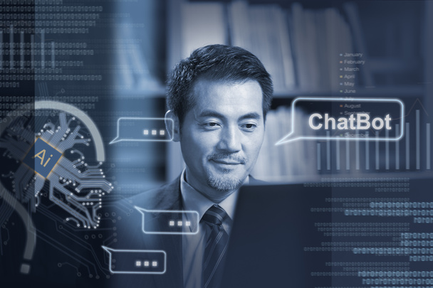 азиатский бизнесмен, сидящий за столом и общающийся с AI ChatBot с помощью ноутбука - Фото, изображение