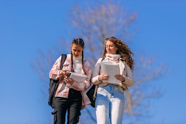Lovely high school girls holding books walking - Photo, Image
