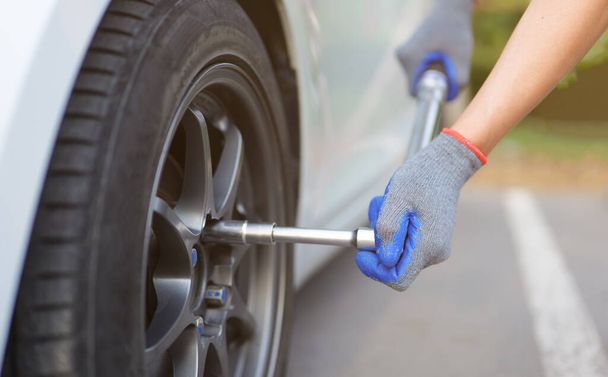 Men tighten car wheel nuts for safety check with Torque Wrench. Car Repairs, vehicle maintenance, car mechanic, Car inspection and maintenance concept. - Foto, Imagen