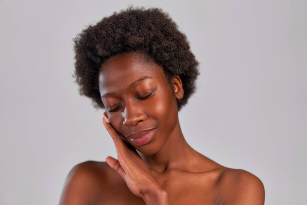 Mujer joven afroamericana con cabello afro y una piel sana perfecta y suave aislada sobre fondo gris. Tratamientos de cuidado de la piel y spa. - Foto, imagen