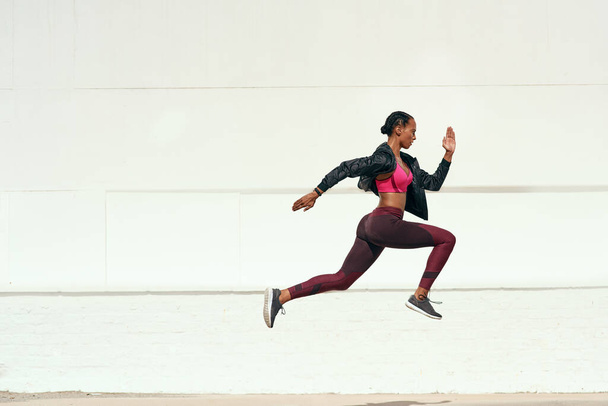Woman, fitness and running jump action on mockup for cardio training, exercise or workout outdoors. Fit, active and sporty female person or runner exercising for health and wellness on mock up space. - Photo, Image