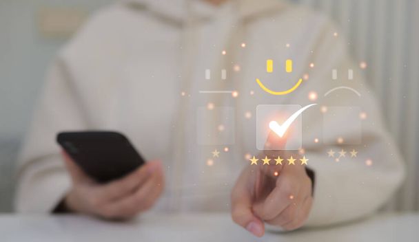 Customer service evaluation concept, Woman choosing on the happy smiley face emoticon satisfaction in service. best rating positive, quality review, feedback survey, marketing performance, excellent, - Фото, изображение
