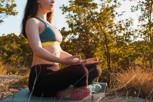 Joven hermosa mujer haciendo yoga y meditando en el Parque. El concepto de yoga, deportes y meditación. De cerca.. - Foto, Imagen