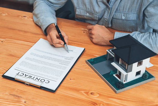 New home owner signing house loan or rental lease contract after agreeing to term and condition with real estate agent. Contract document with clients signature as housing business concept. Entity - Photo, Image