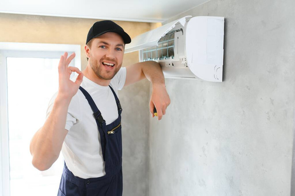 Happy Male Technician Repairing Air Conditioner - Zdjęcie, obraz