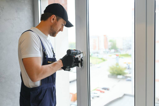 Construction worker repairing window in house - Foto, Imagen